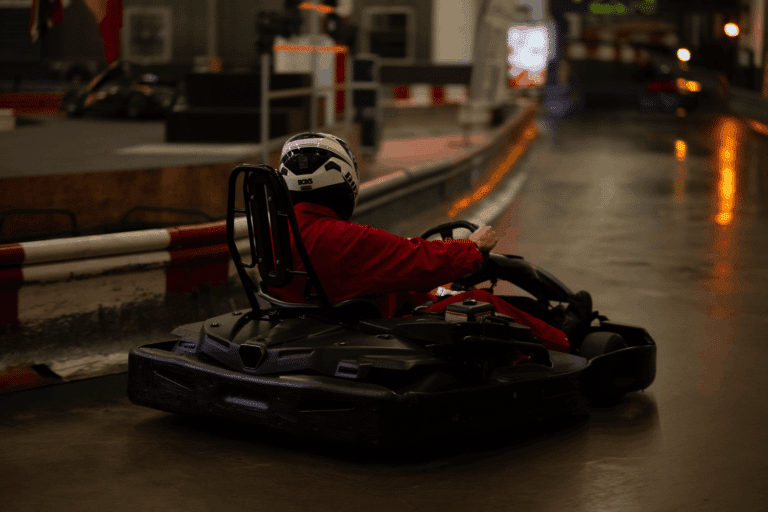 Ein Fahrer im roten Overall in einer Kurve von hinten gesehen beim Kartcenter Cologne, Kartfahren Köln.