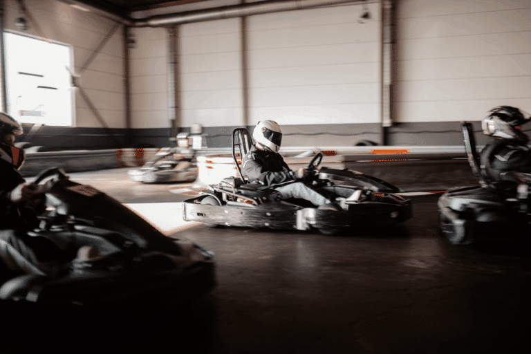 Mehrere Karts fahren mit Abstand im Wettkampf in einer Kurve beim Kartcenter Cologne, Kartfahren Köln.