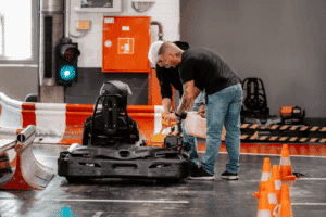 Zwei Mitarbeiter des Kartcenter Cologne betanken ein Kart für das Kartfahren Köln mit Benzinkanistern.