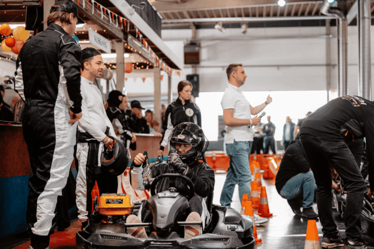 Fahrer in ihren Karts und Mitarbeiter im Startbereich des Kartcenter Cologne, bereit für Kartfahren Köln.